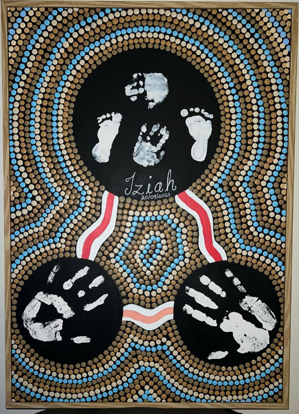 The Iziah commission — a custom Aboriginal dot painting with parent and baby handprints hand-painted in gold and brown dots on black canvas